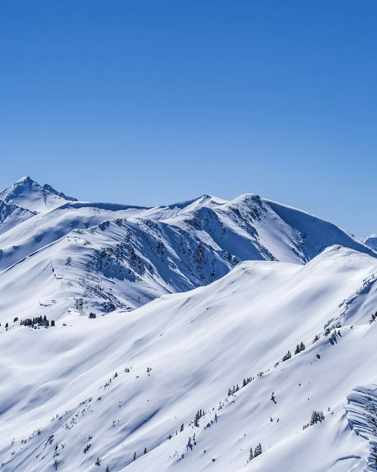 Snow-covered mountain peaks under a clear blue sky