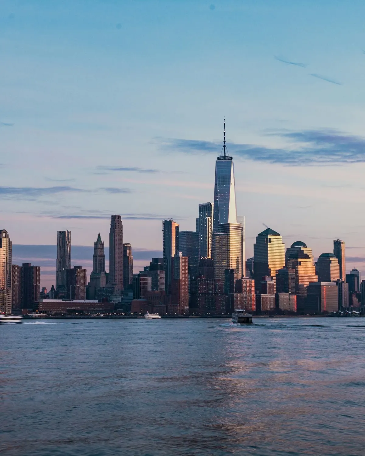 Lower Manhattan skyline across the Hudson at dusk